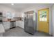 Bright kitchen features a stainless steel refrigerator, yellow door, and hexagon tile flooring at 5603 N Taliaferro Ave, Tampa, FL 33604