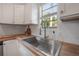 Modern kitchen sink features butcher block countertops and lots of natural light from a window at 5603 N Taliaferro Ave, Tampa, FL 33604