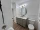 Bright bathroom featuring a gray vanity with marble countertop, updated lighting, and tiled walls at 6008 N Olive Ave, Tampa, FL 33614