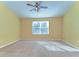 Spacious bedroom with a ceiling fan, large window, and plush carpeting at 6255 Osprey Lake Cir, Riverview, FL 33578