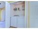 A laundry room with a washer and dryer, storage shelves, and bi-fold doors at 6255 Osprey Lake Cir, Riverview, FL 33578
