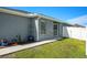 Exterior of house with a walkway, a garden, and lush green grass in backyard at 6863 Hanworth Ln, Zephyrhills, FL 33541