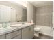 Bathroom featuring gray tiling, light wood floors, and modern marble countertops at 6863 Hanworth Ln, Zephyrhills, FL 33541