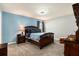 Bedroom with blue accent wall, carpeted floor, and a ceiling fan with light at 6863 Hanworth Ln, Zephyrhills, FL 33541