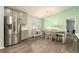 Dining area adjacent to kitchen with stainless steel fridge and chandelier lighting at 6863 Hanworth Ln, Zephyrhills, FL 33541