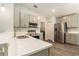 Bright kitchen features stainless steel appliances, gray cabinets, and white countertops at 6863 Hanworth Ln, Zephyrhills, FL 33541