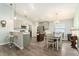 Open-concept kitchen and dining area with stainless steel appliances, island, and modern finishes at 6863 Hanworth Ln, Zephyrhills, FL 33541