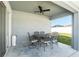 Covered patio with a ceiling fan overlooking a landscaped backyard and white fence at 6863 Hanworth Ln, Zephyrhills, FL 33541