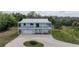 Two-story home featuring a white metal roof and a spacious balcony overlooking the front yard at 73 Sunset Ln, Terra Ceia, FL 34250