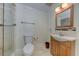 Well-lit bathroom featuring a walk-in shower, wooden vanity, and updated fixtures, next to toilet at 820 Druid S Rd, Clearwater, FL 33756