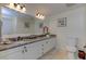 Bright bathroom with granite countertop, double sinks, framed mirror, and tiled floor at 820 Druid S Rd, Clearwater, FL 33756