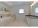 Bright bathroom featuring a soaking tub, elegant vanity with granite countertop, and modern fixtures at 820 Druid S Rd, Clearwater, FL 33756