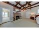Cozy bedroom with a brick fireplace, wood-beamed ceiling, neutral carpet, and an adjacent sunroom view at 820 Druid S Rd, Clearwater, FL 33756