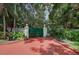 Gated entrance featuring a red brick driveway and lush landscaping at 820 Druid S Rd, Clearwater, FL 33756