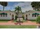 Charming home exterior with a symmetric facade, red brick pathway, and green awnings at 820 Druid S Rd, Clearwater, FL 33756