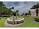 Outdoor view featuring a classic fountain, lush greenery, and partial water view at 820 Druid S Rd, Clearwater, FL 33756