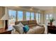 Cozy living room featuring glass doors to the water, a comfortable leather sofa, and tasteful decor at 820 Druid S Rd, Clearwater, FL 33756