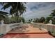 Expansive terrace view with ornate railings, lush landscaping, and a glimpse of the waterfront property at 820 Druid S Rd, Clearwater, FL 33756