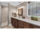 Bathroom with dark wood vanity with marble countertop, framed mirror, and walk-in shower with neutral tile at 8390 39Th N Ave, St Petersburg, FL 33709