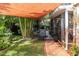 Charming patio with a shade structure, lush greenery, a brick pathway, and outdoor seating at 8390 39Th N Ave, St Petersburg, FL 33709