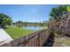 Backyard view featuring lawn, landscaping, fencing and water view at 9224 Lost Mill Dr, Land O Lakes, FL 34638