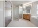 Bright bathroom featuring a glass enclosed shower, wooden vanity, and soaking tub at 9224 Lost Mill Dr, Land O Lakes, FL 34638