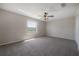This bedroom has a ceiling fan and a view of the lush backyard at 9224 Lost Mill Dr, Land O Lakes, FL 34638