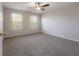 Spacious bedroom featuring plush carpeting, two windows, and a ceiling fan at 9224 Lost Mill Dr, Land O Lakes, FL 34638