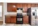 Well-maintained kitchen with black appliances, stone flooring, and wood cabinetry at 9224 Lost Mill Dr, Land O Lakes, FL 34638