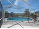 Enclosed pool with safety fence and screened-in lanai offering backyard views at 9224 Lost Mill Dr, Land O Lakes, FL 34638