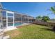 View of the screened in pool area with a beautiful yard and landscaping at 9224 Lost Mill Dr, Land O Lakes, FL 34638