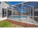 Exterior view featuring lawn, landscaping, and enclosed pool with screened-in lanai at 9224 Lost Mill Dr, Land O Lakes, FL 34638