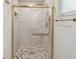 Modern bathroom shower features marble tile, patterned floor and gold hardware at 1012 Cronley Pl, Sarasota, FL 34237