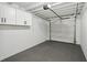 Clean garage with white walls, gray floor, white cabinets, and garage door at 1012 Cronley Pl, Sarasota, FL 34237
