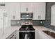 Close-up of kitchen featuring granite countertops, stainless steel appliances, and updated cabinetry at 1012 Cronley Pl, Sarasota, FL 34237