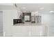 Modern kitchen with white cabinets, stainless steel appliances, and a breakfast bar at 1012 Cronley Pl, Sarasota, FL 34237