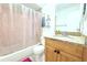 Cozy bathroom with a shower/tub combo, single sink vanity with granite counter and decorative art on the walls at 10131 Lake Oak Cir, Tampa, FL 33624