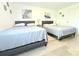 Sunlit bedroom boasts two beds, modern décor, and wood-look vinyl floors perfect for comfortable living and relaxation at 10131 Lake Oak Cir, Tampa, FL 33624