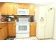 Well-equipped kitchen with a white refrigerator, stove, and plenty of wooden cabinet storage space at 10131 Lake Oak Cir, Tampa, FL 33624