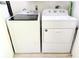 Laundry area with a modern, front-loading washing machine and a top-loading dryer at 10131 Lake Oak Cir, Tampa, FL 33624