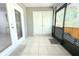 Enclosed patio featuring tile floors, a screened wall, and white sliding glass doors at 10131 Lake Oak Cir, Tampa, FL 33624