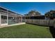 Green backyard with swimming pool and screened in patio at 1028 Rosetree Ln, Tarpon Springs, FL 34689