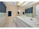 Bathroom with double sinks, tile floors, and shower with neutral and blue accents at 1028 Rosetree Ln, Tarpon Springs, FL 34689