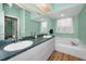 Elegant bathroom featuring double sinks, bathtub, and modern fixtures at 1028 Rosetree Ln, Tarpon Springs, FL 34689