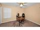 Bedroom with neutral walls, ceiling fan, and window with desk setup and carpeted floors at 1028 Rosetree Ln, Tarpon Springs, FL 34689
