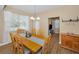 Charming dining area featuring a wooden table set with views of the backyard and kitchen at 1028 Rosetree Ln, Tarpon Springs, FL 34689