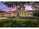 Charming home exterior with well-manicured lawn and inviting front porch at 1028 Rosetree Ln, Tarpon Springs, FL 34689