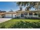 Charming home with a inviting porch, a lush lawn, and a convenient two-car garage at 1028 Rosetree Ln, Tarpon Springs, FL 34689