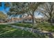 Landscaped front yard of the home, complete with mature trees and a sidewalk at 1028 Rosetree Ln, Tarpon Springs, FL 34689