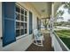 Inviting front porch with a rocking chair, providing a relaxing outdoor space at 1028 Rosetree Ln, Tarpon Springs, FL 34689